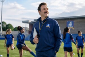 Ted Lasso FC 27 entouré des joueurs et joueuses de l'AFC Richmond